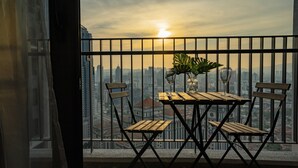 A balcony with a table and chairs, a potted plant, and a cityscape view. - The Mews Jalan Yap Kwan Seng by Joanne (Kuala Lumpur)
