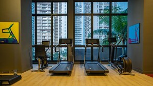 A gym with two treadmills, a rowing machine, and a stationary bike. - The Mews Jalan Yap Kwan Seng by Joanne (Kuala Lumpur)