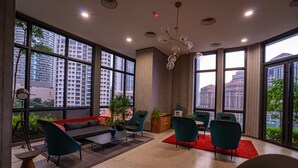 A modern interior with large windows, a sofa, chairs, a coffee table, and a red rug. - The Mews Jalan Yap Kwan Seng by Joanne (Kuala Lumpur)