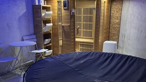 Una habitación con una piscina inflable grande, muebles de madera y una sauna integrada.