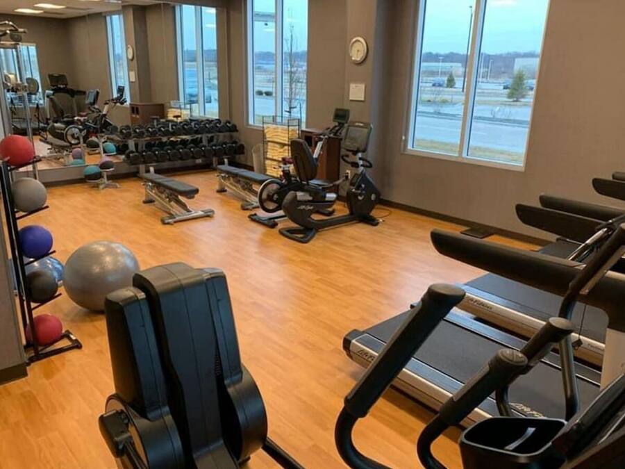 Ein Fitnessstudio mit Cardiogeräten, Kurzhanteln und Trainingsbällen.