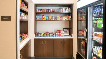 A small convenience store with shelves stocked with snacks, beverages, and other items.