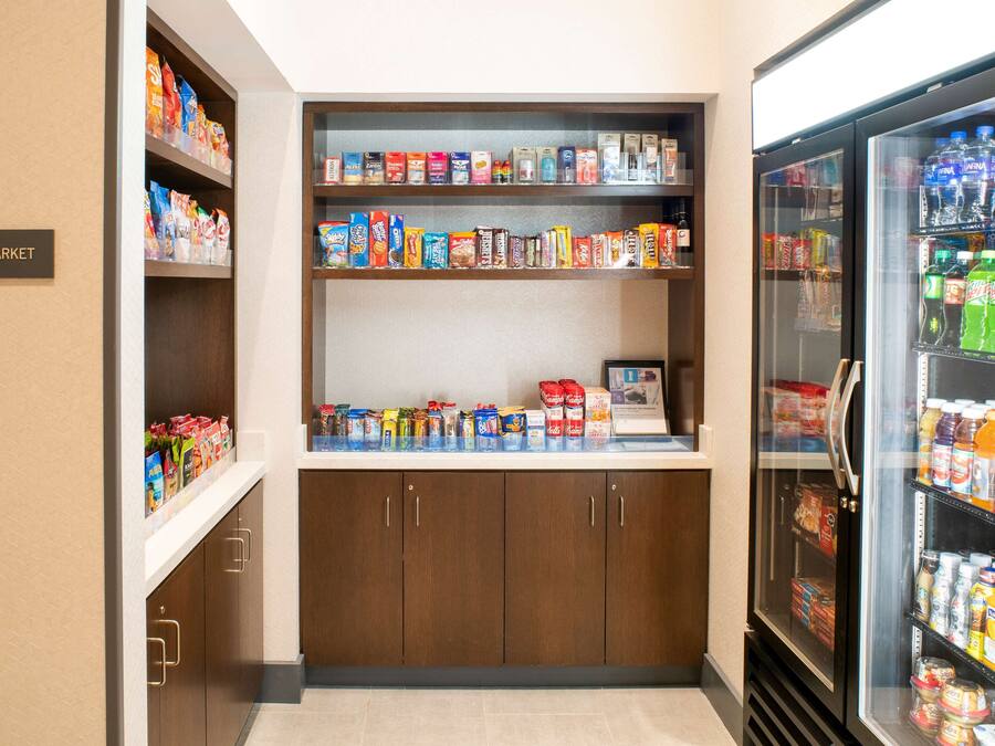 Ein kleiner Kiosk mit Regalen voller Snacks, Getränke und anderer Waren.