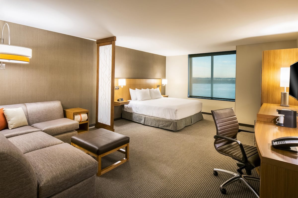 Ein Hotelzimmer mit Bett, Sofa, Schreibtisch und Sessel.