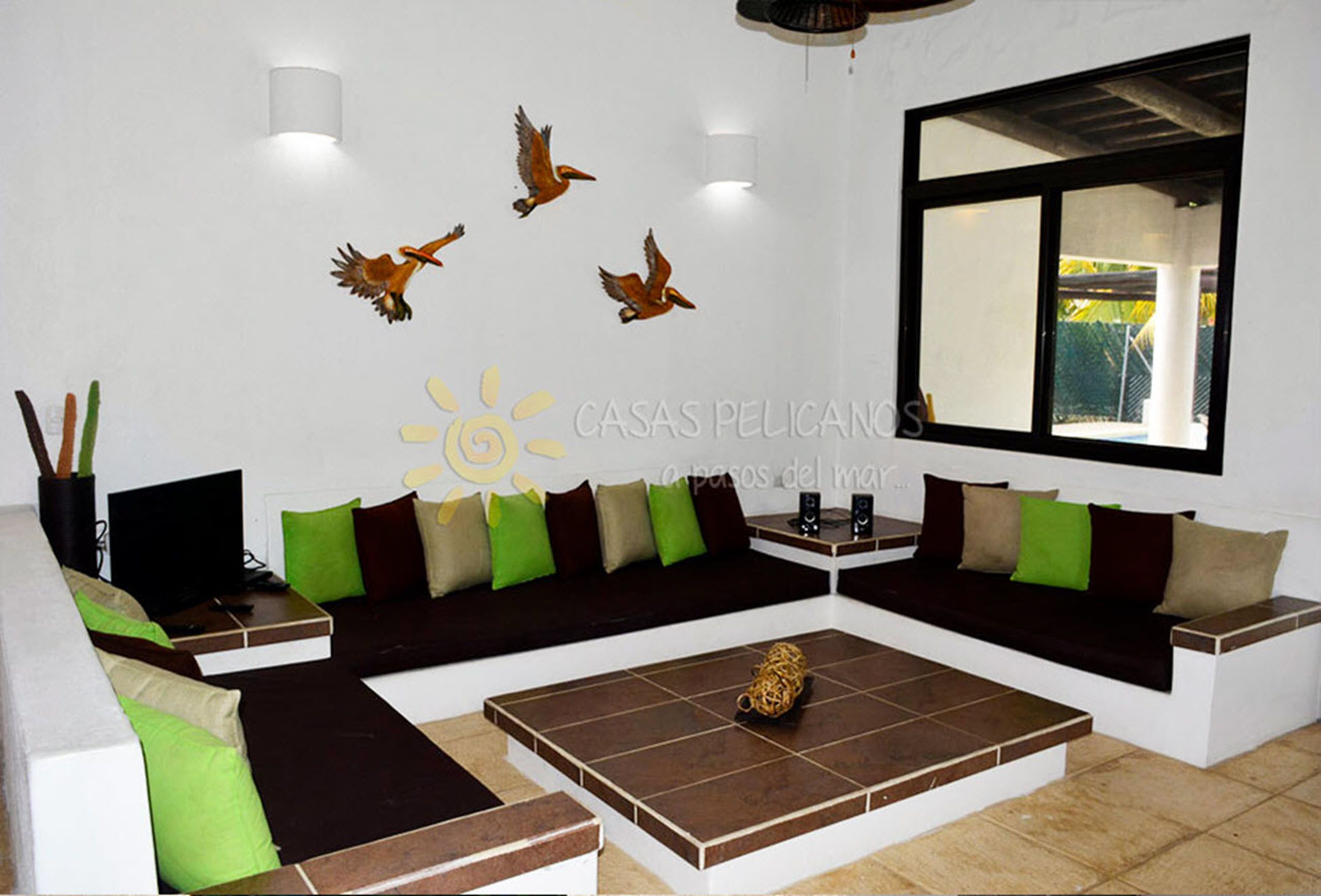 A modern living room with a sectional sofa, a coffee table, and wall art of flying birds.
