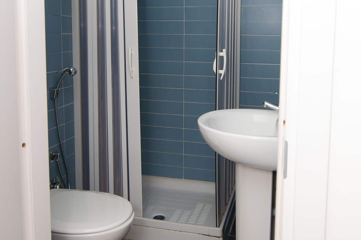 A bathroom with a shower, toilet, and sink.