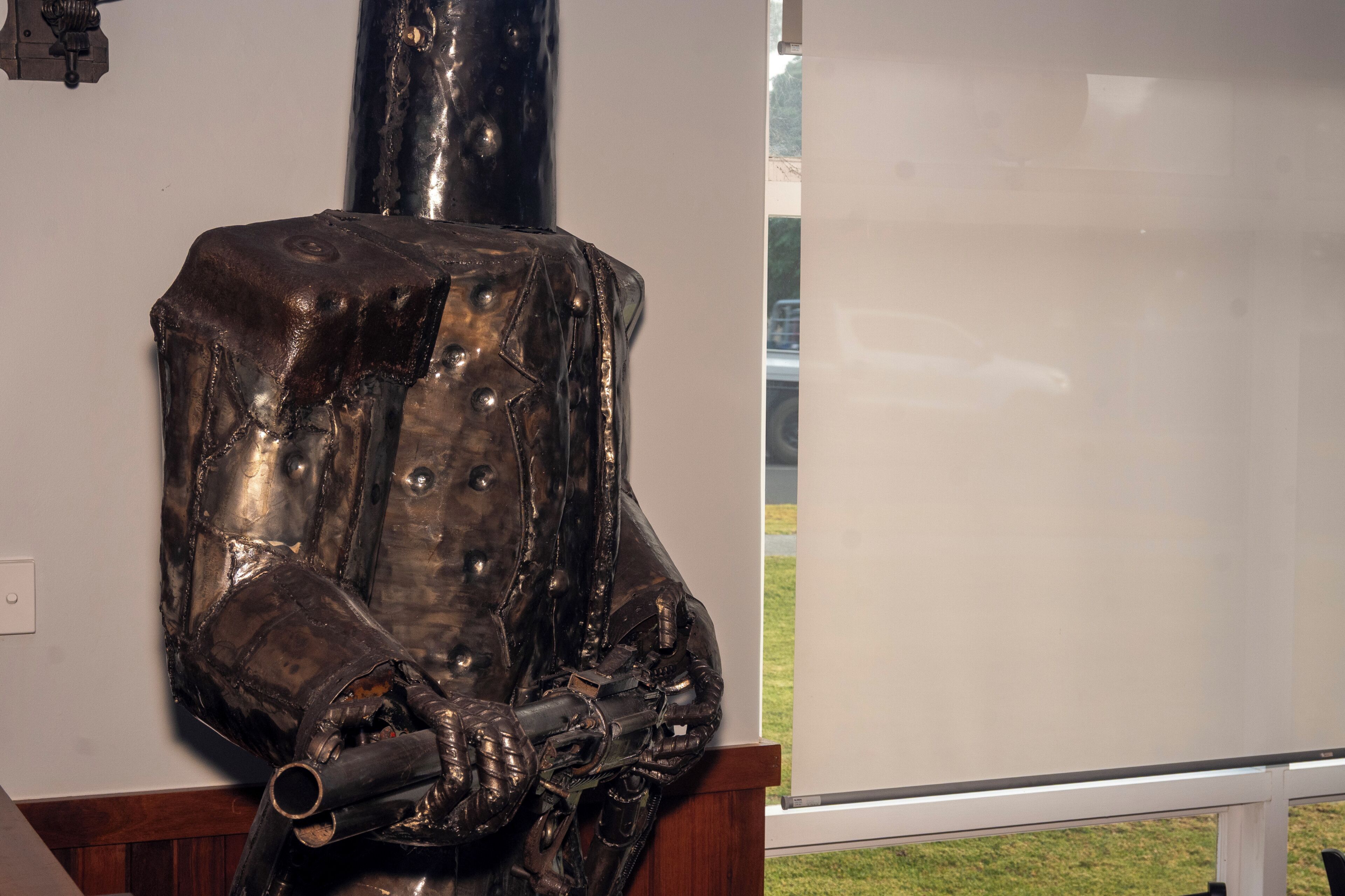 Una escultura metálica con una base cilíndrica y una forma abstracta compleja.