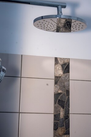 A showerhead with a circular design and a metallic finish.