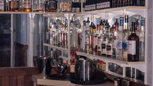 A bar area with shelves stocked with various liquor bottles, a metal mixing station, and a sink. - Manjimup Motor Inn (Manjimup)