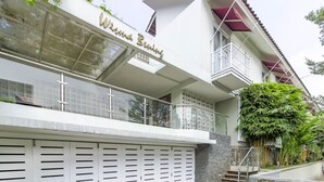 Een modern gebouw met balkon, trap en garage.