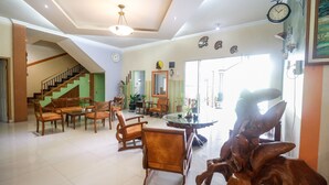 Amplia sala de estar con escalera, muebles de madera y una gran escultura de madera.