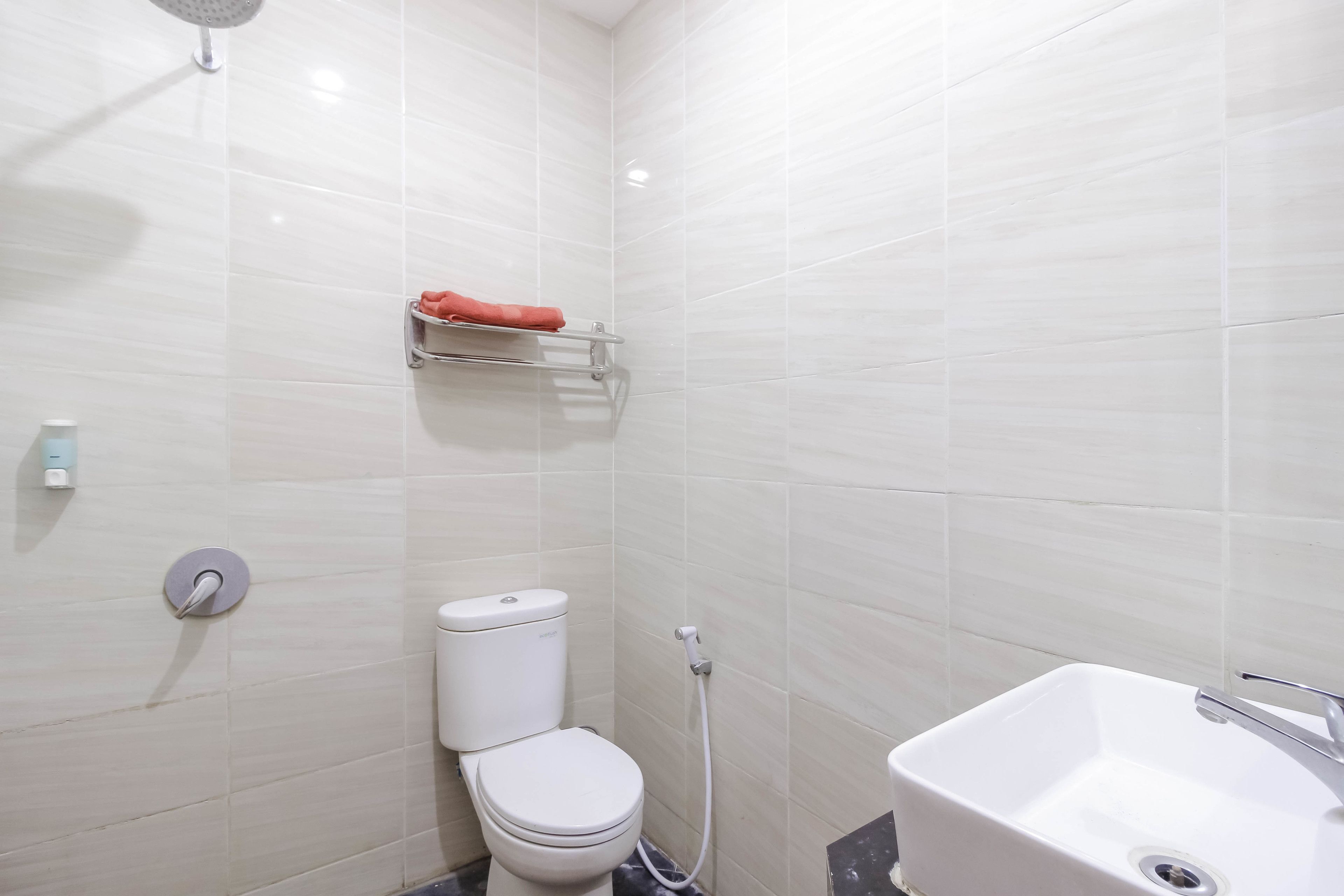 A modern bathroom with a toilet, a shower, and a sink.