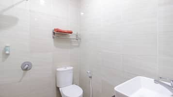 A modern bathroom with a toilet, a shower, and a sink.