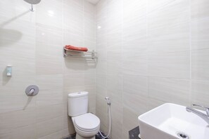 Un baño moderno con inodoro, ducha y lavamanos.