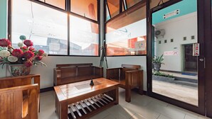 A room with wooden furniture, a window with a view of the outside, and a door with a sign.