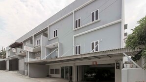 A multi-story residential building with balconies, a garage, and a covered entrance.