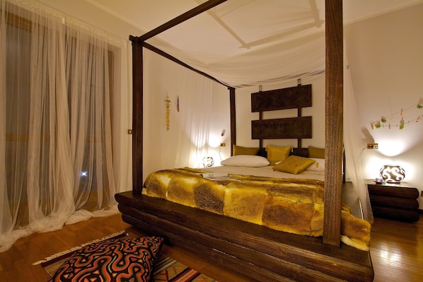 A four-poster bed with a headboard, a bedside table, and a nightstand. - AURORA Suite apartment Lake Orta-beach00311600048 (pettenasco)