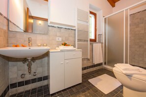 Een bad/douchecombinatie, een haardroger, een bidet, handdoeken