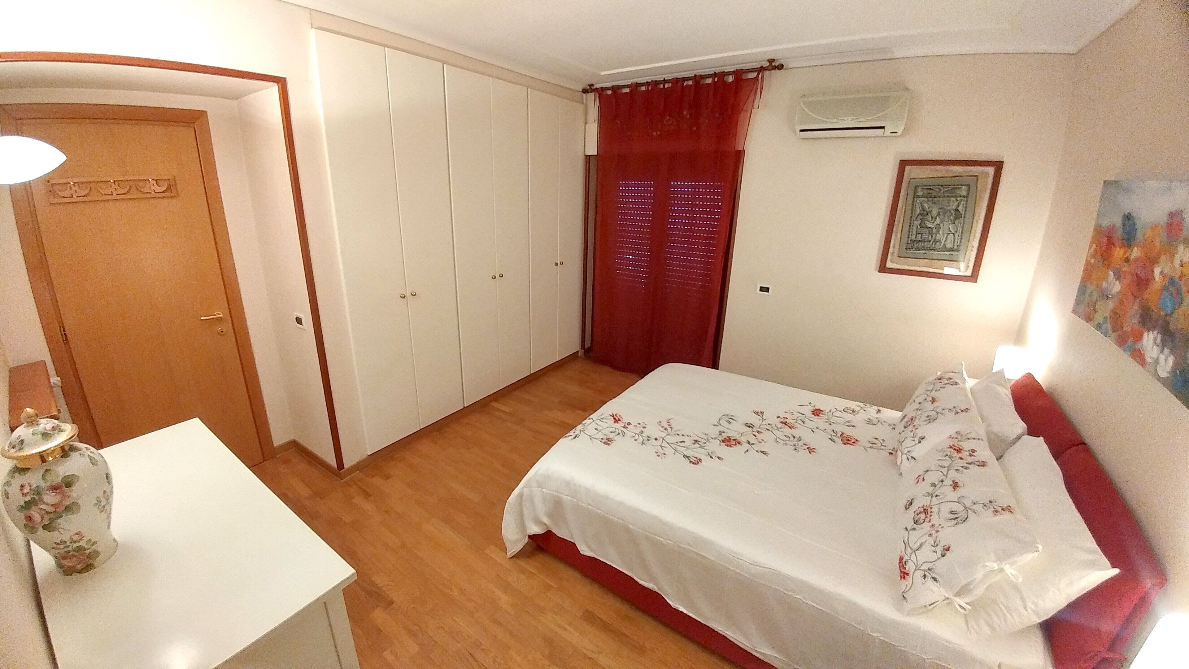 Une chambre à coucher avec un lit, un bureau, une armoire et un tableau au mur.