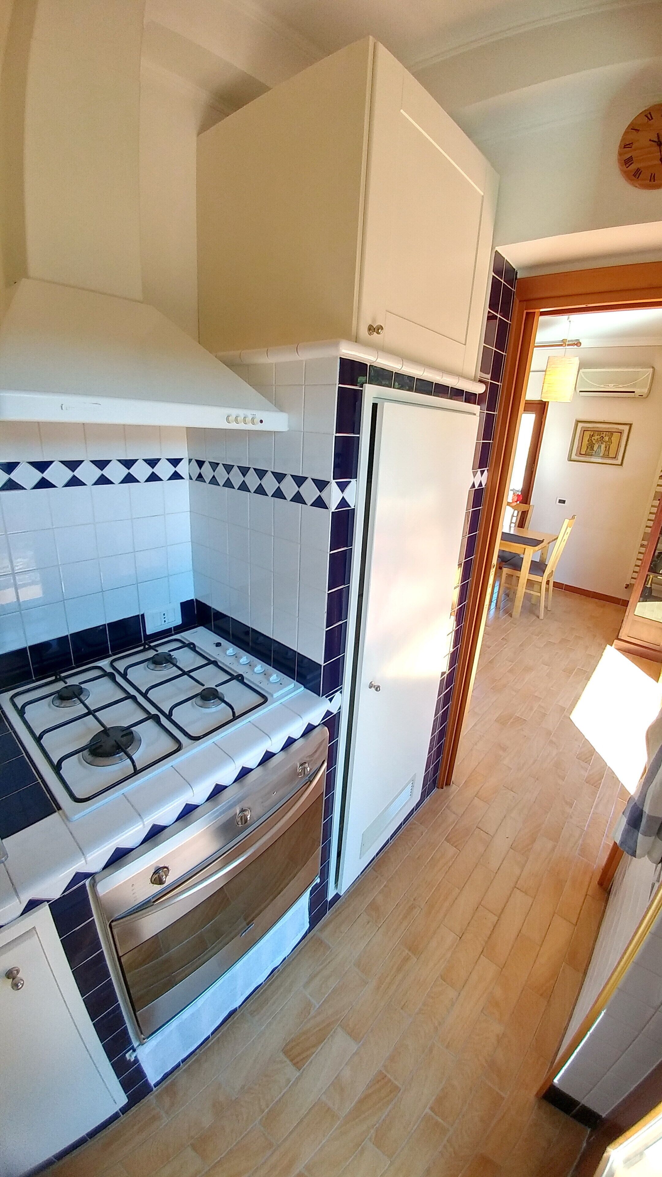 A kitchen with a gas stove, oven, and white refrigerator.