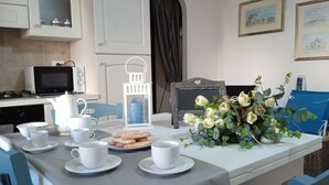 Une table à manger dressée avec des tasses, des soucoupes et une assiette de biscuits.