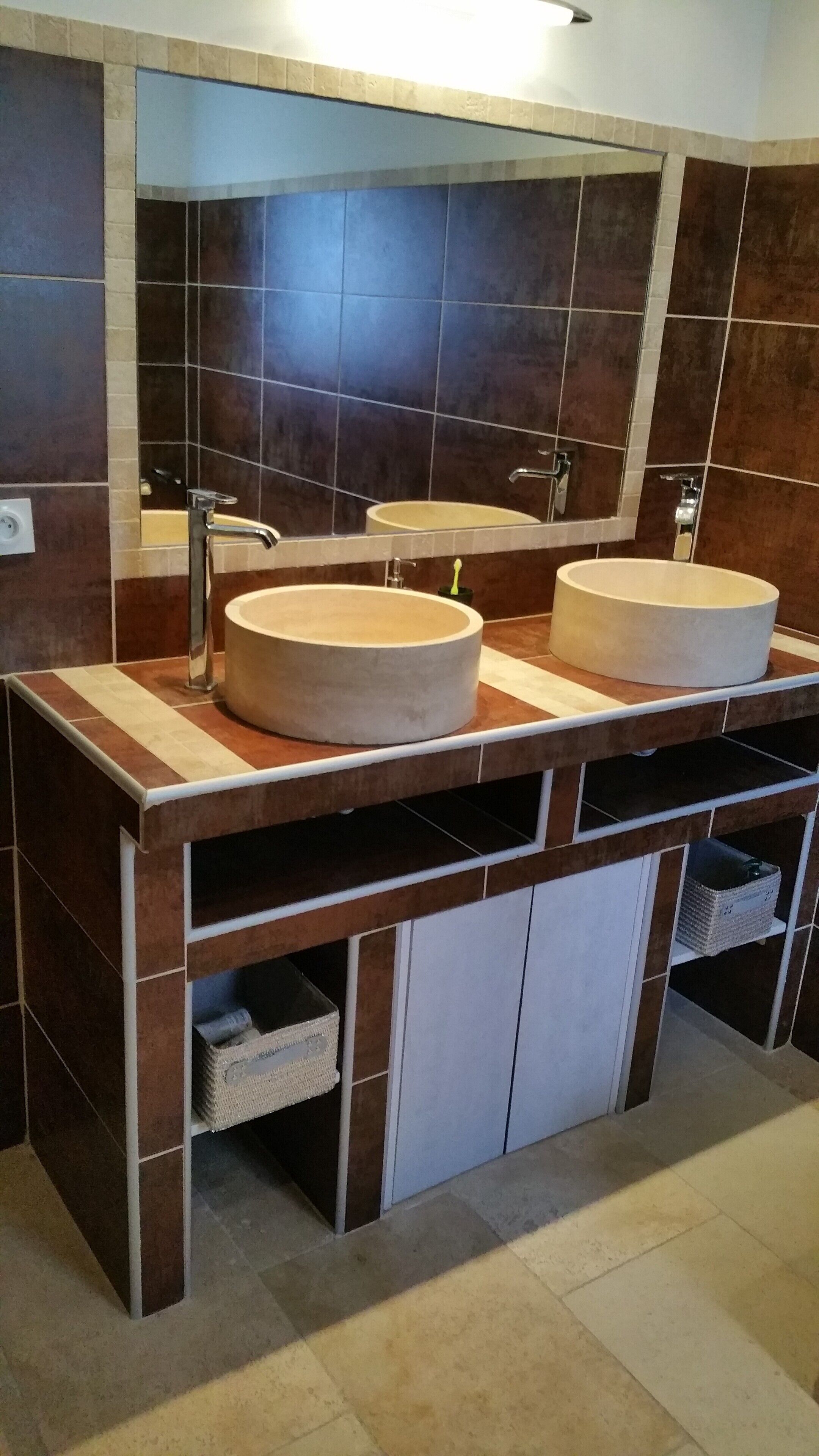 Ein Badezimmer mit zwei runden Waschbecken, einem Spiegel und einem Handtuchhalter.