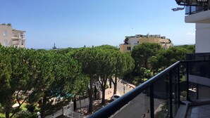 Un quartiere residenziale con edifici moderni, cielo sereno e vista sul mare.