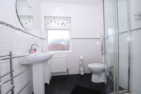 A modern bathroom with a sink, toilet, and glass shower enclosure. - Lovely house with a mature garden and is fully serviced and a home from home (Belfast)