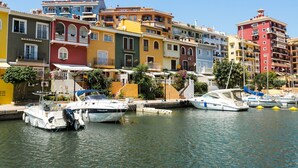 A marina with colorful buildings and boats docked. - ApartUP Saplaya Harbour (Alboraya)