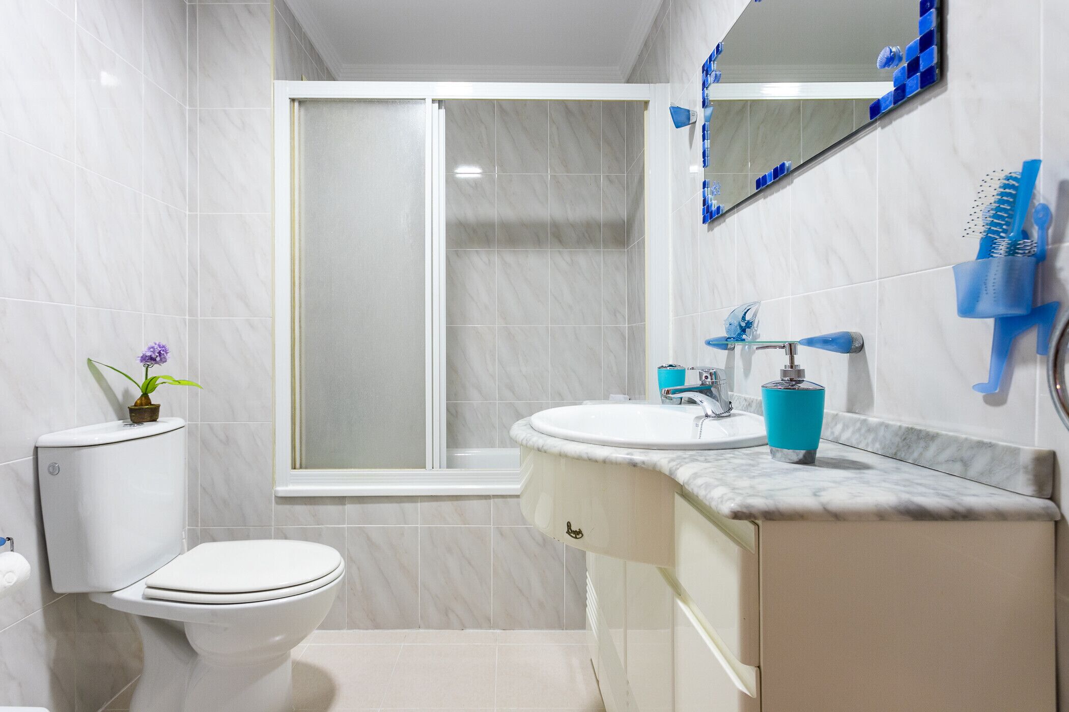 A modern bathroom with a toilet, sink, and shower.