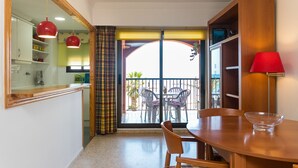 A dining area with a wooden table, chairs, and a red lamp. - ApartUP Saplaya Harbour (Alboraya)