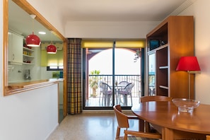 A dining area with a wooden table, chairs, and a red lamp. - ApartUP Saplaya Harbour (Alboraya)