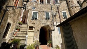 Un edificio de piedra con un arco central, una torre de campana y una escalera que lleva a la entrada.