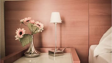 Ein Nachttisch mit Blumen in einer Vase und einer Lampe.