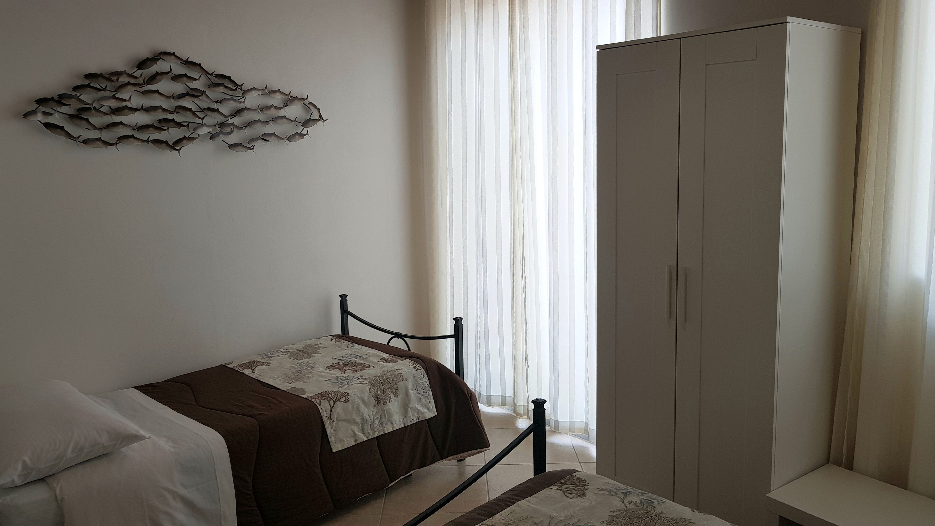 Ein Schlafzimmer mit einem Bett, einem Kleiderschrank und einem Wanddekor.
