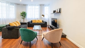 Una sala de estar moderna con un conjunto de sofá, una mesa de centro y un televisor.