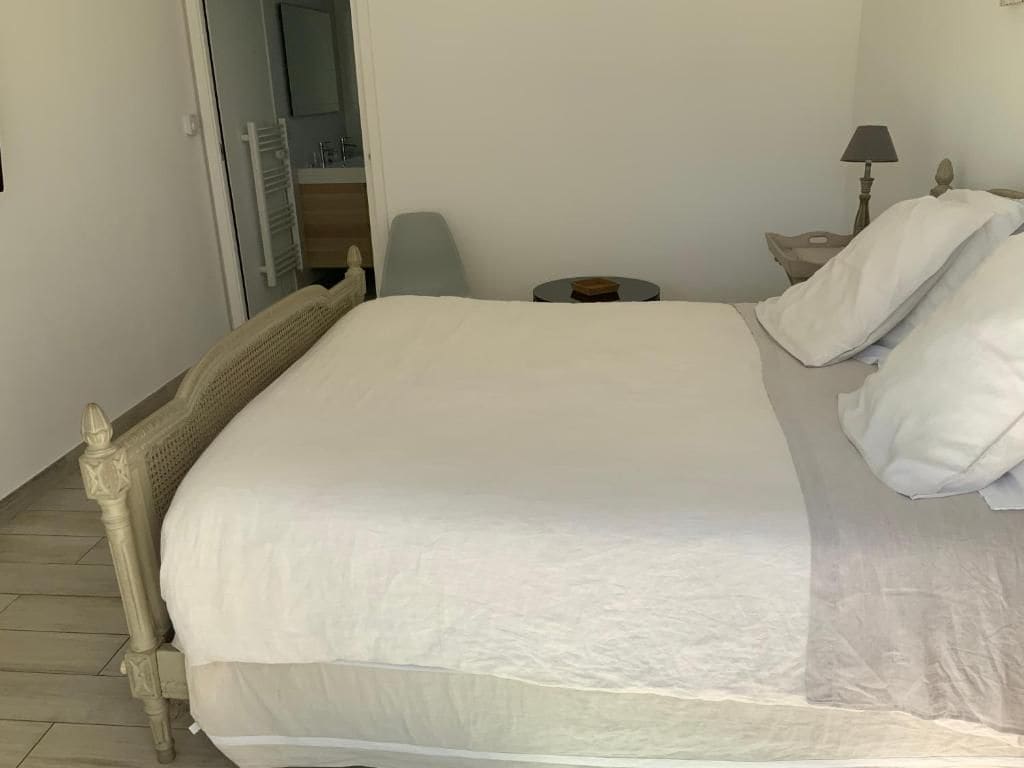 Une chambre à coucher avec un lit, une table de chevet, une lampe et une chaise.