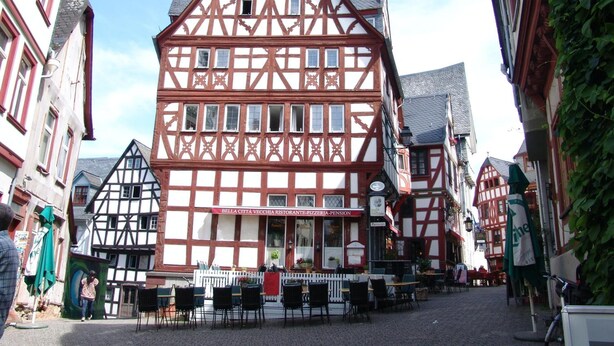 Ein traditionelles Fachwerkhäuschen mit einem Restaurant namens "Bella Città Vecchia Ristorante Pizzeria-Pension" im Erdgeschoss.