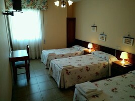 Habitación de hotel con dos camas, un escritorio y una silla.