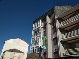 Un edificio de varios pisos con un letrero verde que indica un hotel llamado 'Hotel R. Mayo'.