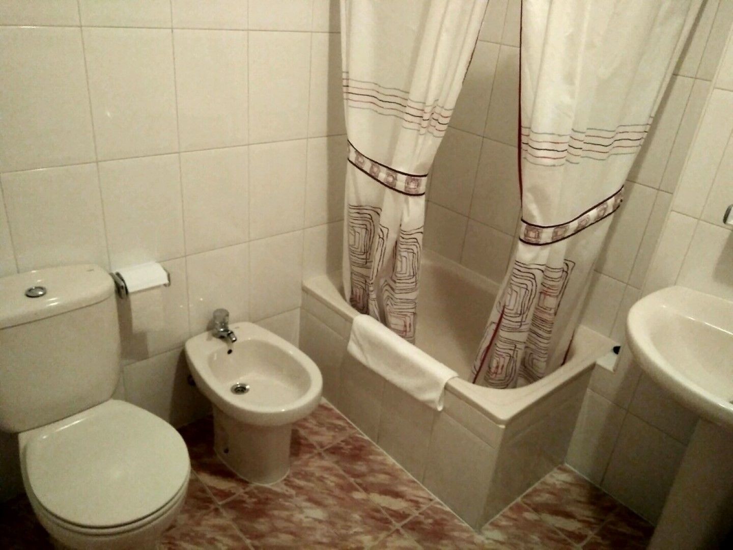 Ein Badezimmer mit Toilette, Bidet und Waschbecken.