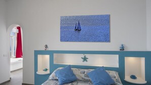 A bedroom with a bed, a wall-mounted picture of a sailboat, and a starfish decoration. - Casa Mimì in Moressa area (Praiano)