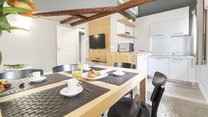 Una cocina moderna con armarios blancos, horno empotrado y microondas.