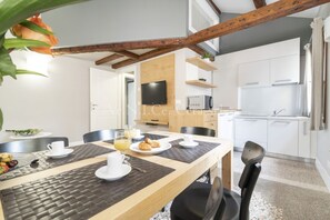 A modern kitchen with white cabinets, a built-in oven, and a microwave.