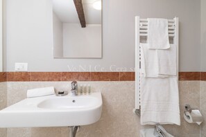 A bathroom with a white sink, mirror, and towel rack. - Ve.N.I.Ce Cera San Marco Terrace (Venezia)