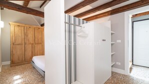 Un dormitorio con cama, armario de madera y armario blanco con estantes.