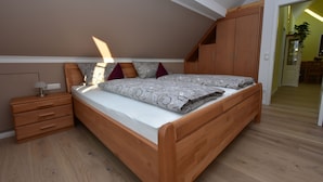Un dormitorio con una cama de madera, una mesita de noche y un armario.