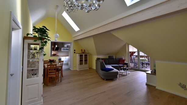 Un loft amplio con techos altos, comedor, sala de estar con sofá y cocina.