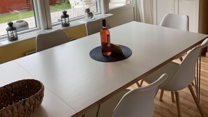 A modern dining room with a large table, white chairs, and a unique chandelier. - Idyllic holiday home near Örkelljunga, sun terrace, wood-burning stove, forests and lakes (Örkelljunga)
