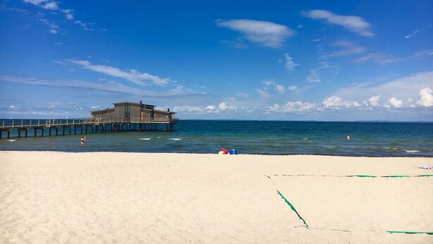 A beach with a wooden pier extending into the sea, a sandy beach, and a clear blue sky. - Idyllic holiday home near Örkelljunga, sun terrace, wood-burning stove, forests and lakes (Örkelljunga)